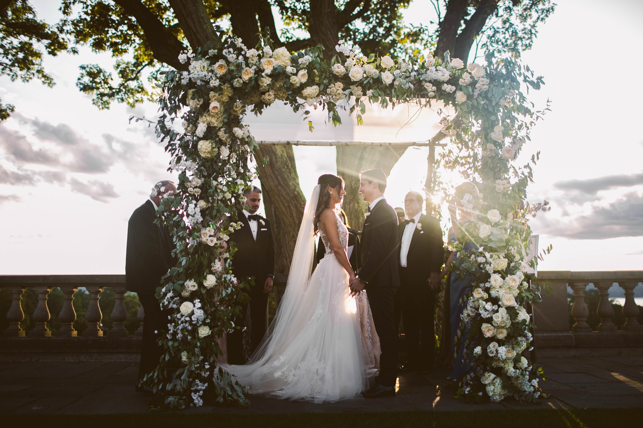 Ceremony beneath a floral chuppah at golden hour, Sleepy Hollow Country Club