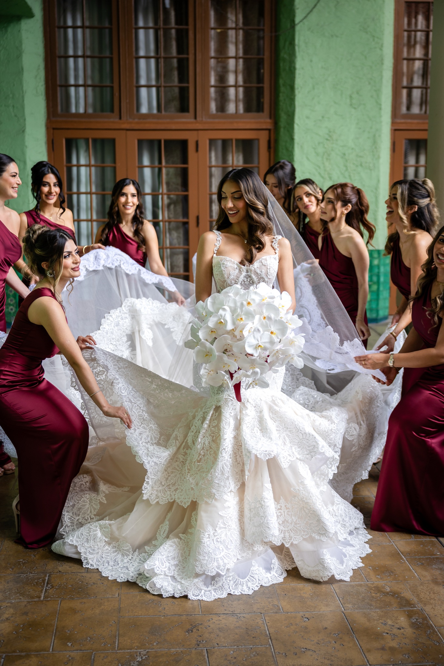 Bride surrounded by her bridesmaids as they lift the train of her gown